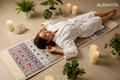 Woman lying on Gemstone Infrared Red Light Therapy Mat in luxury spa setting